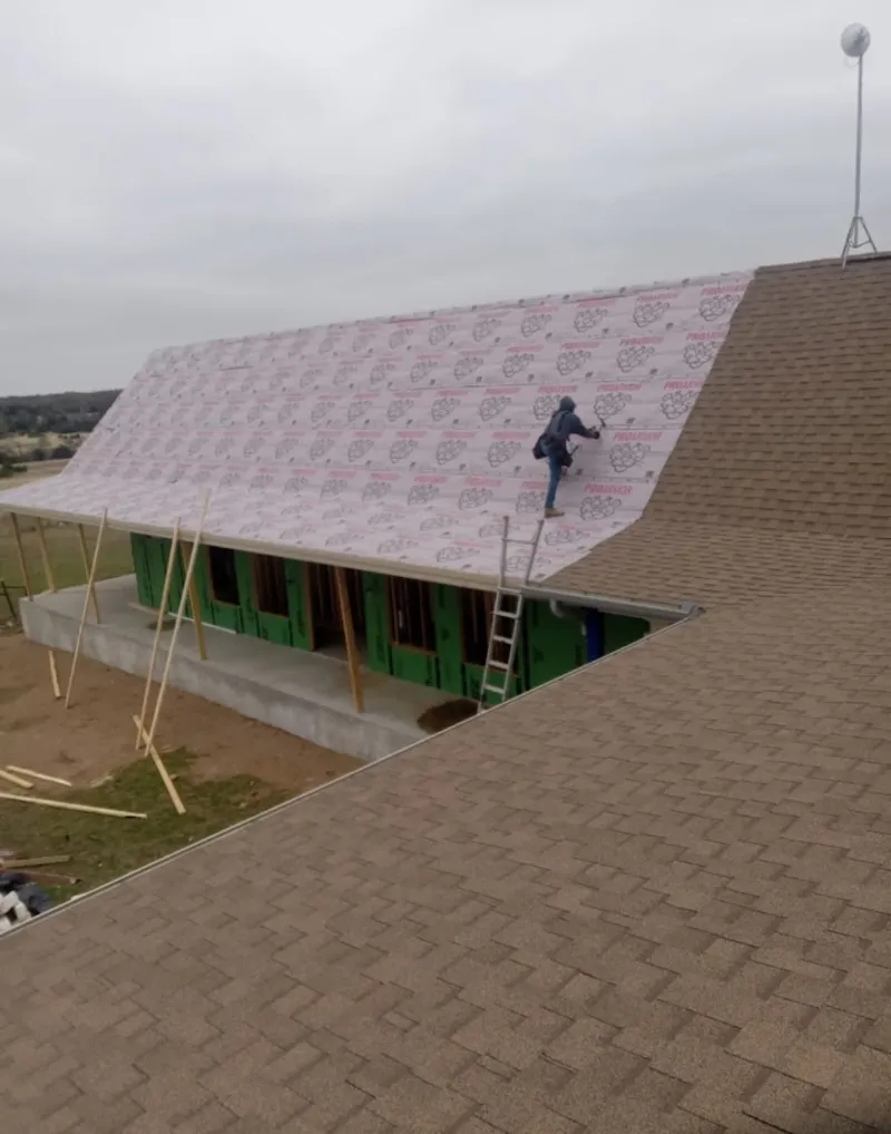 Worker preparing underlayment for a metal roof installation in Croton-on-Hudson